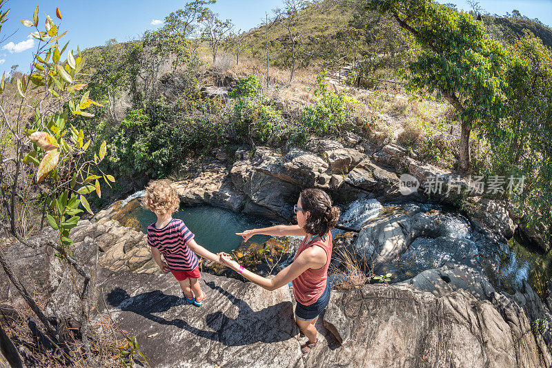 母亲和儿子看着岩石河Pirenópolis Goiás
